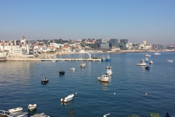 a small boat in a body of water with a city in the background