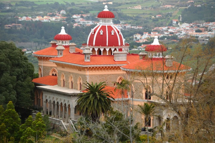 a large white building with a mountain in the background