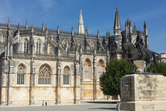 a large stone building with Batalha Monastery in the background