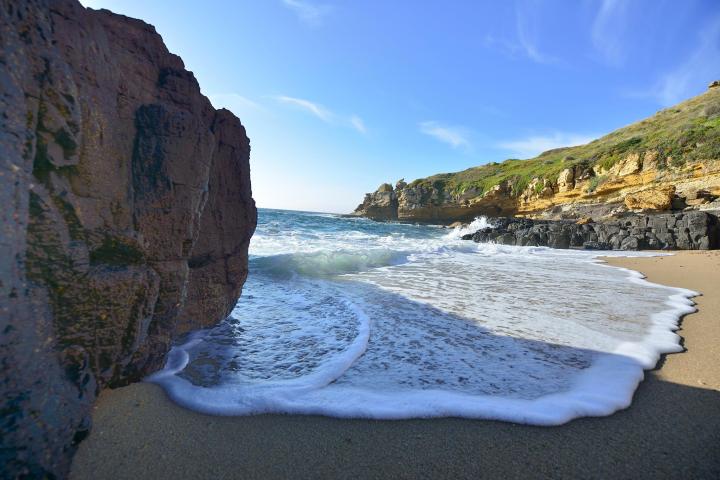 a rocky beach in front of a mountain