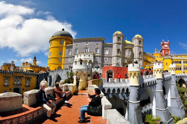 a group of people standing in front of a castle