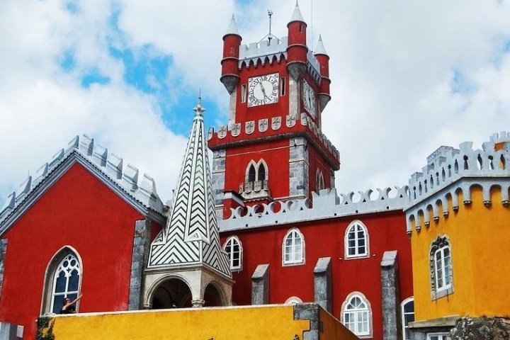 a large red brick tower with a clock on the side of a building