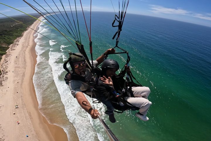 a man sitting next to a body of water