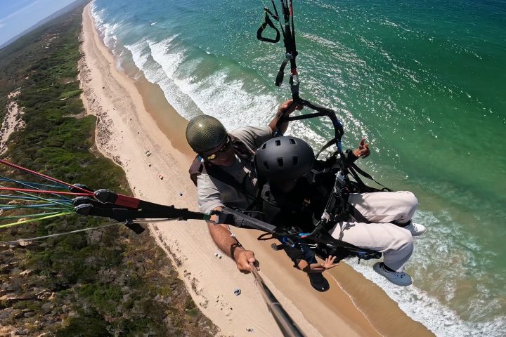 a man sitting next to a body of water