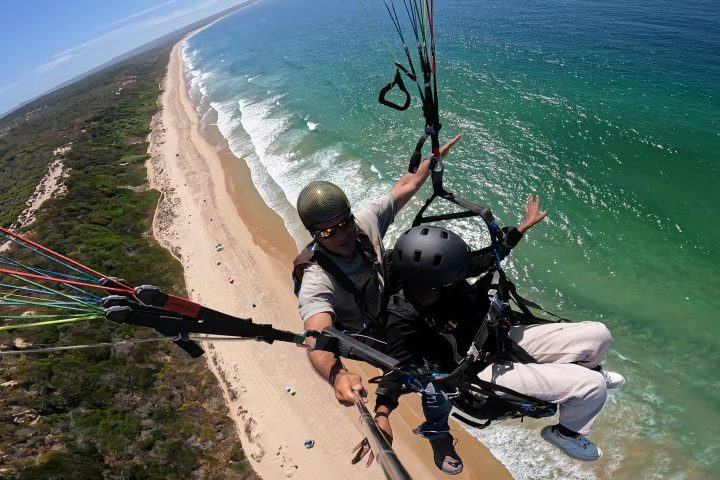a man sitting next to a body of water