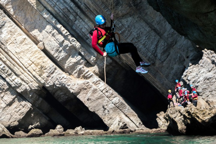 a person flying through the air on a rock
