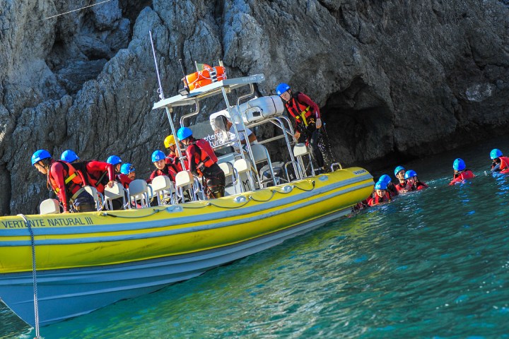 a group of people riding on the back of a boat in the water