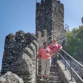 a man standing next to a rock wall