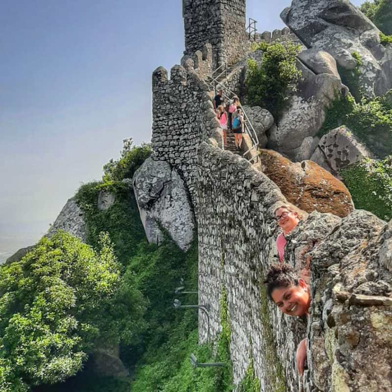 a person standing in front of a large rock