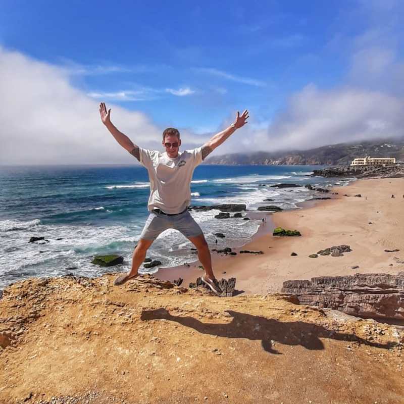 a person throwing a frisbee at the beach