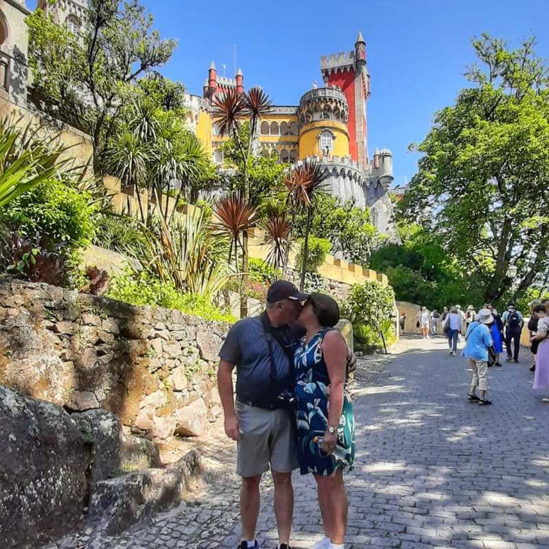 a group of people standing next to a stone wall