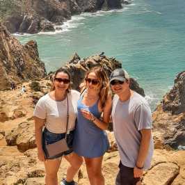 a group of people standing on a rocky beach