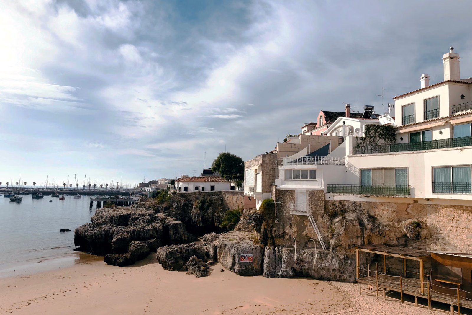 Cascais seafront with rocky shore, sandy beach and historic buildings near Lisbon